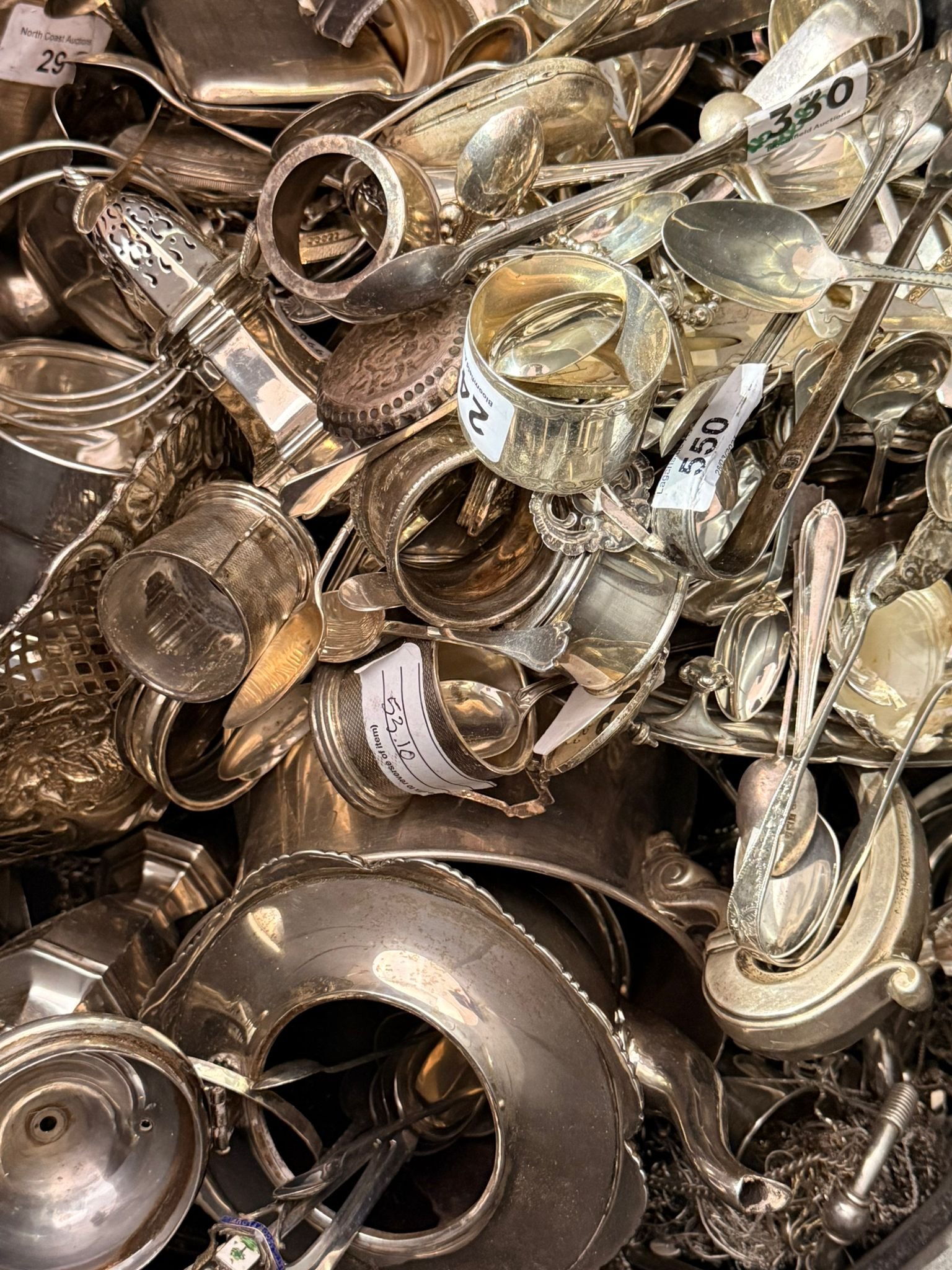 Large collection of silver napkin rings and silverware at auction